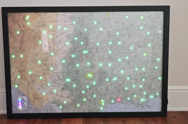 A large framed sectional map on a wood floor with dozens of green lights
