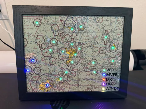 A framed sectional map with green and blue airport lights and a lit legend