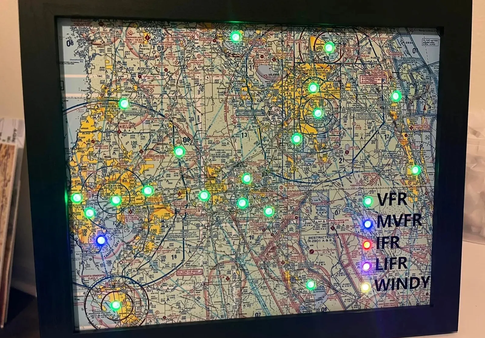 A framed sectional of the Florida peninsula with green and blue airport lights and a lit legend for VFR, MVFR, IFR, LIFR and Windy