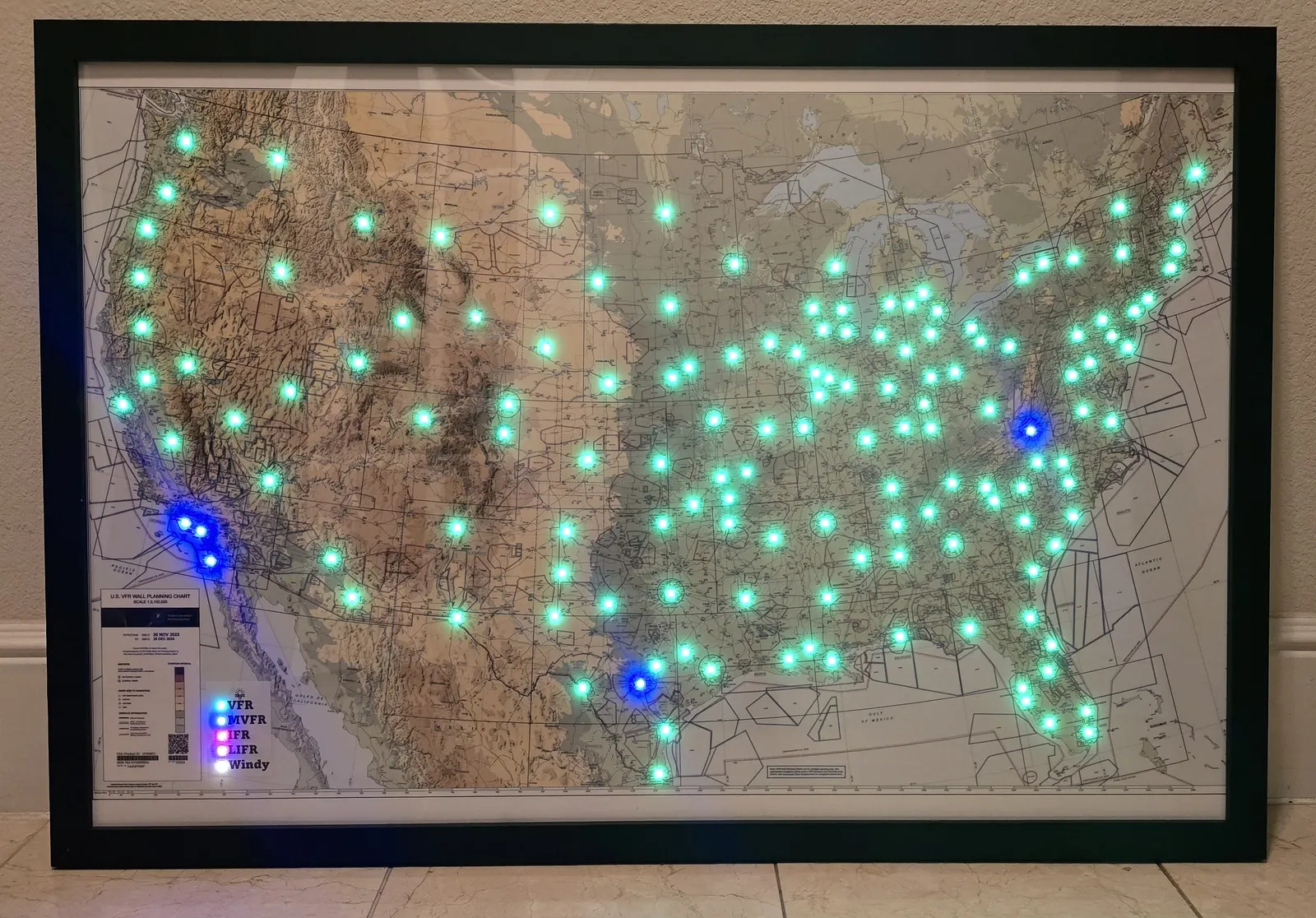 A framed DIY METAR map of the United States with a light at each airport, most green for VFR and a few blue for MVFR